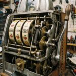 클래식 슬롯머신의 내부를 가로지르는 단면으로, 복잡하게 맞물린 기어와 레버 메커니즘을 자세히 보여주는